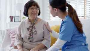 Older adult and family member talk together beside a personalized assisted living room window.