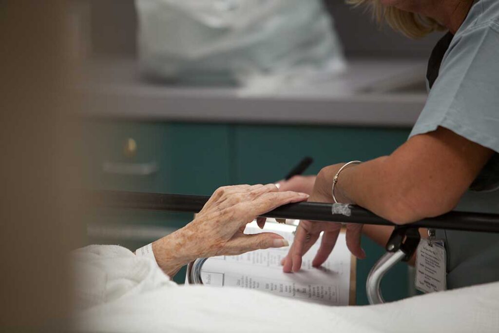 Staff guide older residents through a brightly lit hallway during an assisted living emergency drill.